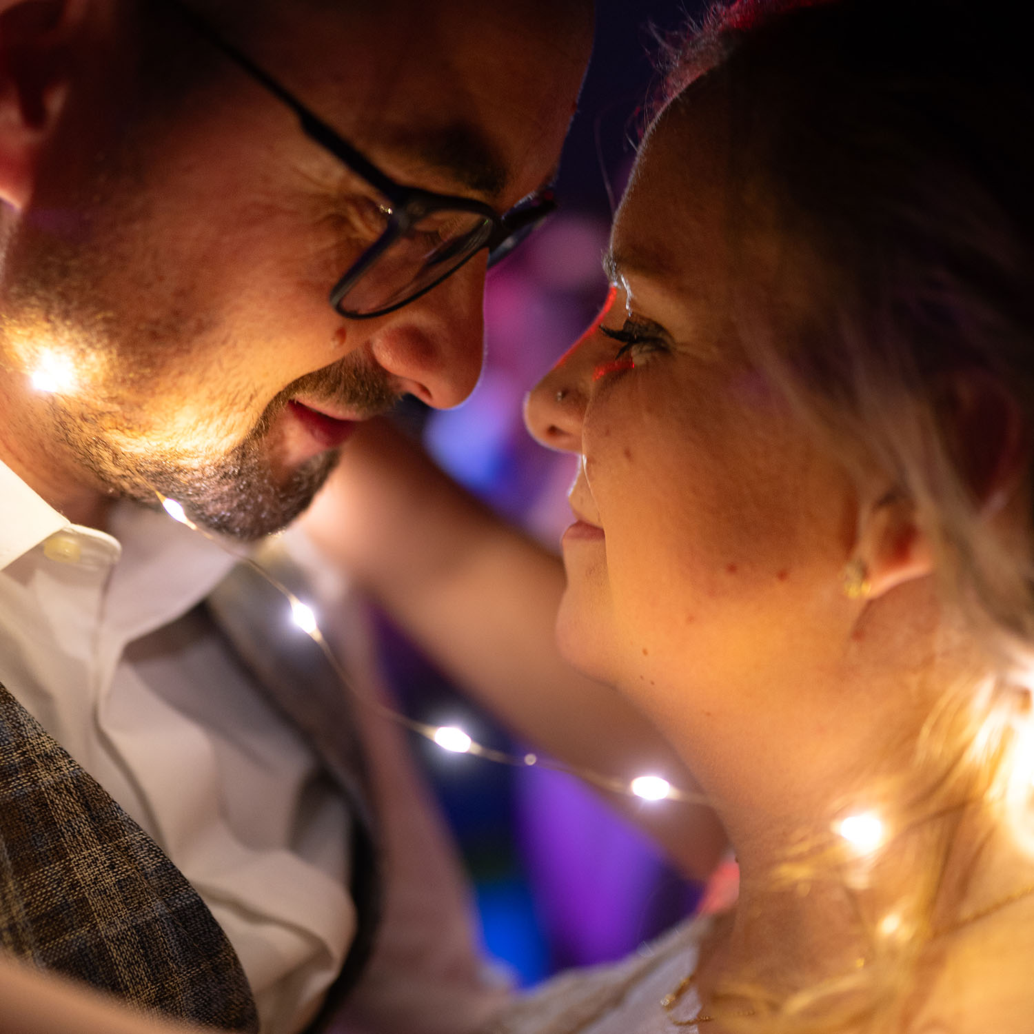 Ein enger Brauttanz auf einer Hochzeit im Allgäu. Das Paar wird durch eine Lichterkette erleuchtet.