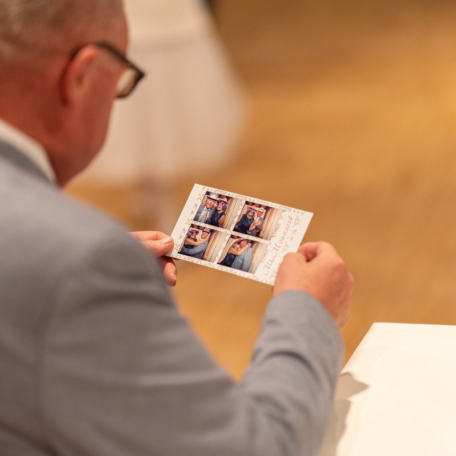 Ein Mann sieht sich in ruhe sofort gedruckte Hochzeitsfotos noch am Hochzeitstag an.