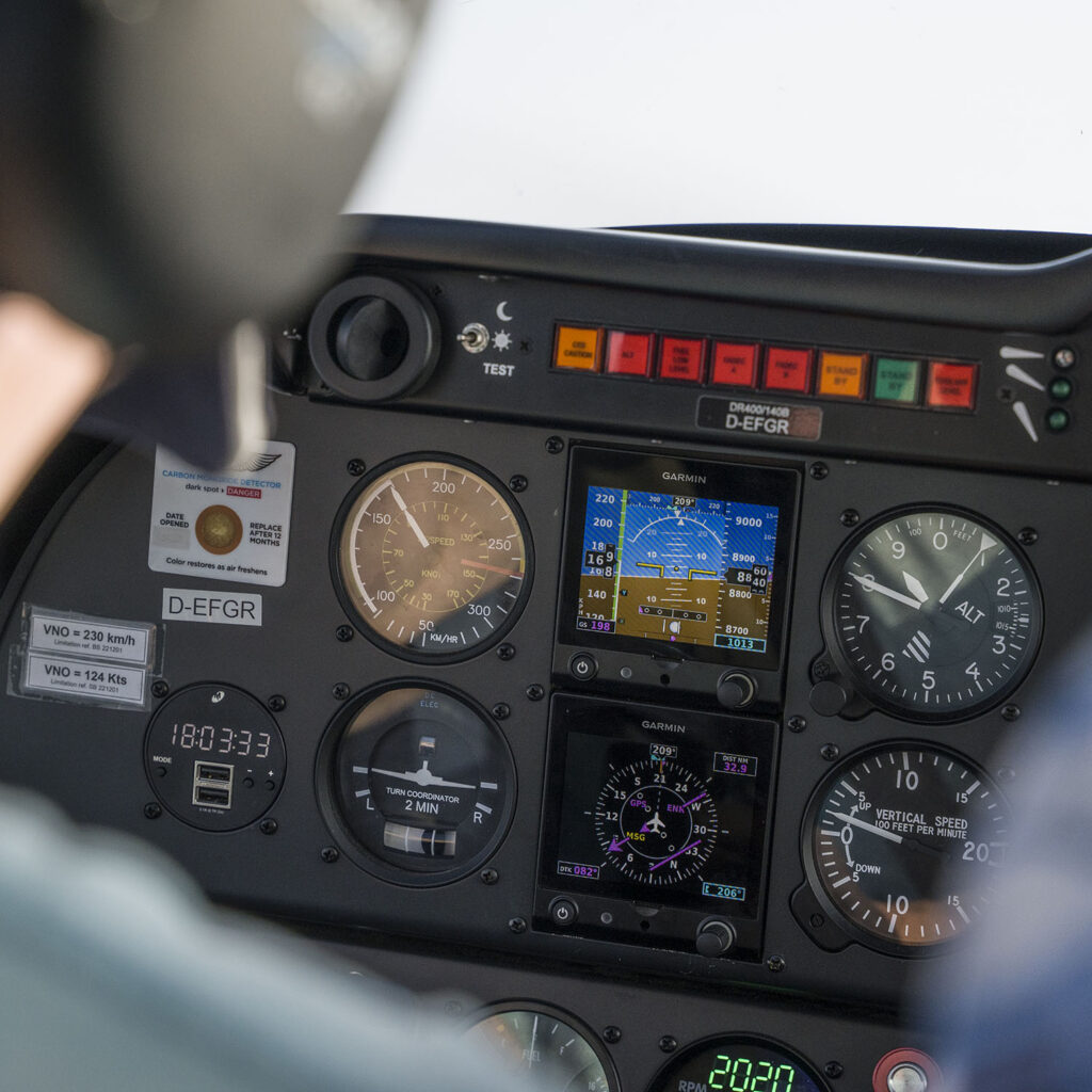 ein Instrumentenboard eines Flugzeugs über den Alpen.