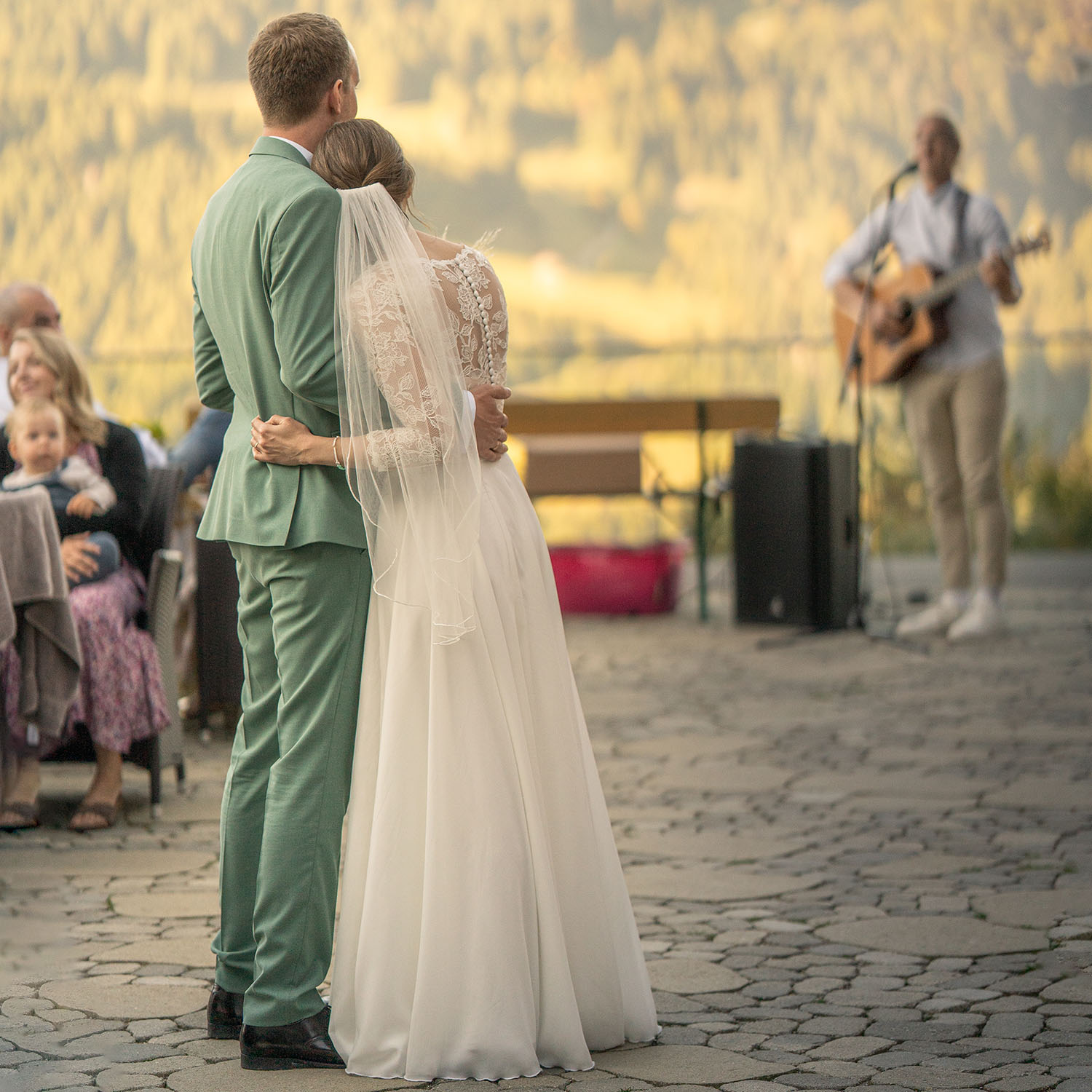 Ein Brautpaar, eng umschlungen, lauscht der Musik auf ihrer Hochzeit.